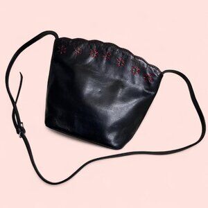 Black leather crossbody bag with red stitching